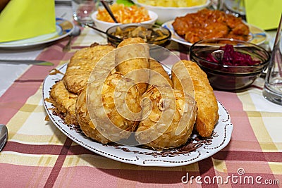A pile of fried, stuffed Polish croquettes lying on a decorated table, visible mushrooms and beets. Stock Photo