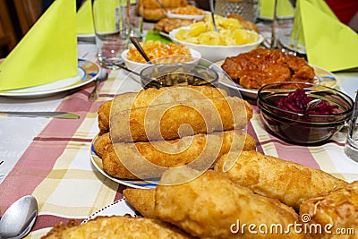 A pile of fried, stuffed Polish croquettes lying on a decorated table, visible mushrooms and beets. Stock Photo
