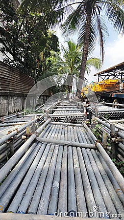 Pile of galvanized pipe under the coconut tree Stock Photo