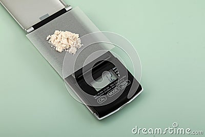 Pile of Guar gum powder on accurate electronic digital scale. Food additive E412, exact dosage. 1.2 grams of guar gum or guaran Stock Photo