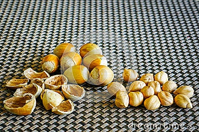A pile of hazelnuts on the table, some peeled, visible kernels and shells Stock Photo
