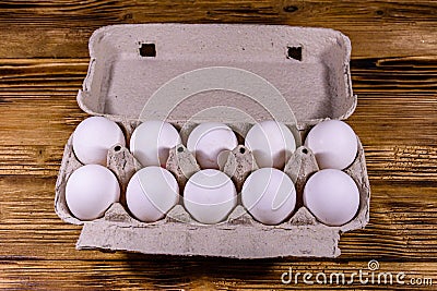 Pile of the hen eggs in paper tray on wooden table Stock Photo
