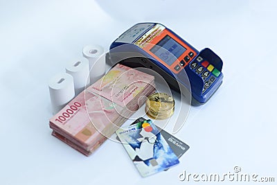 Pile of hundred thousand rupiah banknotes along with BANK BRI credit cards and bitcoins and also an EDC ELECTRONIC DATA CAPTURE Editorial Stock Photo