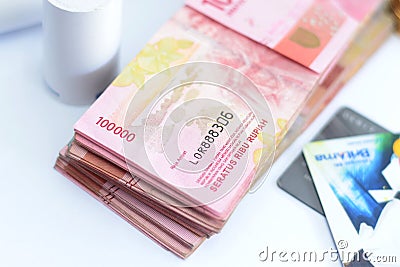 Pile of hundred thousand rupiah banknotes along with BANK BRI credit cards and bitcoins and also an EDC ELECTRONIC DATA CAPTURE Editorial Stock Photo