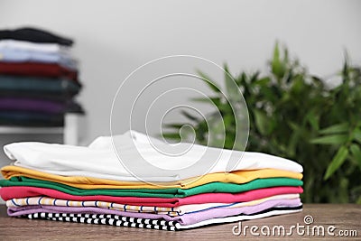 Pile of ironed clothes on table in room Stock Photo