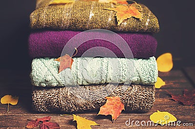 Pile of knitted winter clothes on wooden background covered with Stock Photo