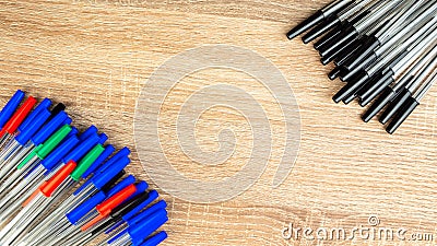 Pile of a lot multi colored plastic ballpoint pens on wooden table. Abstract stationery background. Top view, flat lay. Copy space Stock Photo