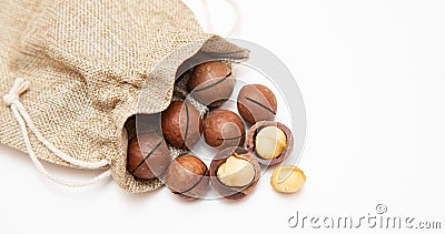 Pile macadamia nuts open kernels and shells in burlap bag on white background, top view Stock Photo