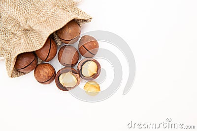 Pile macadamia nuts open kernels and shells in burlap bag on white background, top view Stock Photo