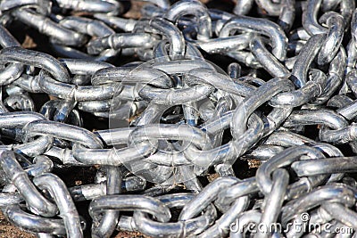 pile metal silver chain lies on the asphalt in the parking car. Stock Photo