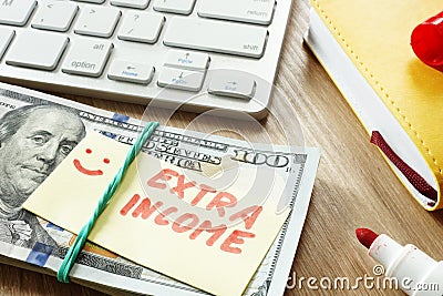 Pile of money with sign Extra income. Stock Photo