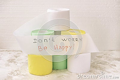 Pile of multicolored rolls of toilet paper on light background, supporting slogan, text. Concept of lack of toilet paper Stock Photo
