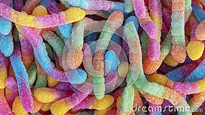 Pile of neon sugary gummy worms or chewy sour crawlers background Stock Photo