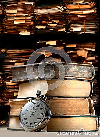 Pile of old books and stopwatch Stock Photo