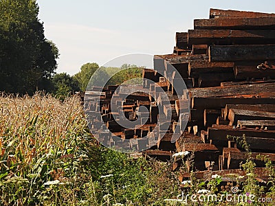 Pile of railway sleepers next to Cornfield Stock Photo