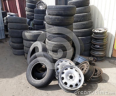 Pile of old tires and wheel rims near the workshop Editorial Stock Photo