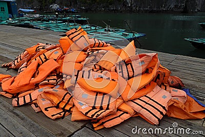 Pile of orange life jackets on a floating dock in ha long bay Editorial Stock Photo