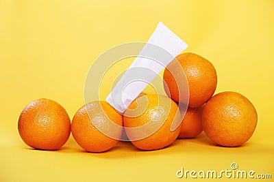 a pile of oranges fruits with vitamin C and empty cream tube. natural anti-cellulite therapy concept Stock Photo