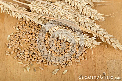 Pile of organic whole grain wheat kernels and ears Stock Photo