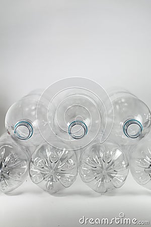Pile of pack of a liter and a half of empty mineral water without caps just with the blue sealing ring on a white Stock Photo