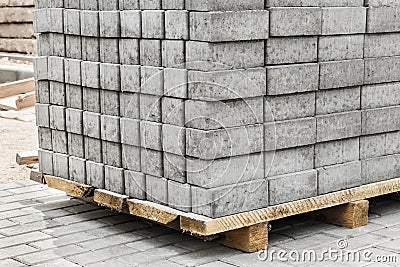 A pile of packed paving stone slabs industrial tile sidewalk materials on wooden pallet at a construction site Stock Photo