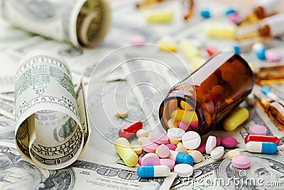 Pile of pharmaceutical drug and medicine pills on dollar money, cost of healthcare and medical insurance Stock Photo