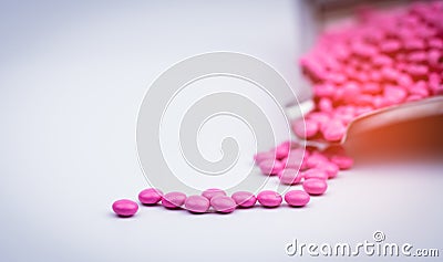 Pile of pink round sugar coated tablets pills on drug tray with copy space. Stock Photo