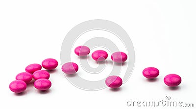 Pile of pink round sugar coated tablets pills isolated on white background with copy space. Stock Photo