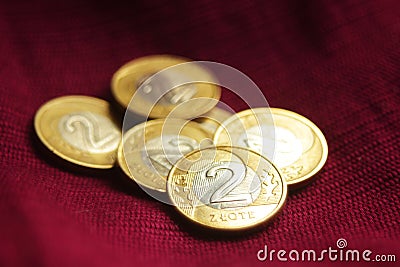 A pile of Polish two zloty coins on royal red-purple background. Stock Photo