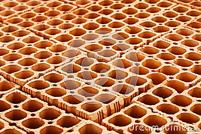 Pile of red hollow bricks with large holes forming a repetition geometric pattern Stock Photo