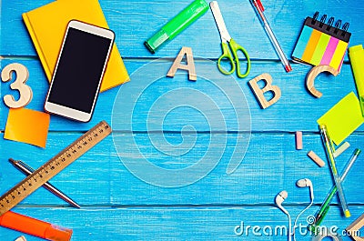 A pile of school supplies on a blue wooden table background. The concept of the educational process, doing homework. Stock Photo