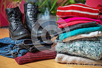 Pile of second hand clothing and shoes with computer on floor Stock Photo