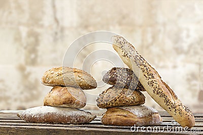 Pile of Several small multi grain different shaped bread and baguette,sprinkled with whole sunflower seeds, flax and Stock Photo