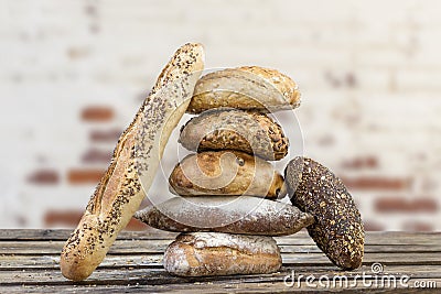 Pile of Several small multi grain different shaped bread and baguette,sprinkled with whole sunflower seeds, flax and Stock Photo