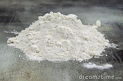 Pile of sifted flour, dark concrete tabletop background. handful of white flour on black background Stock Photo
