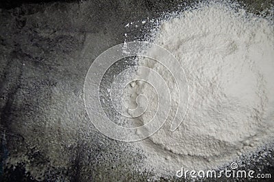 Pile of sifted flour, dark concrete tabletop background. handful of white flour on black background Stock Photo