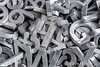 Pile of silver metal alphabet characters cutted by waterjet machine Stock Photo