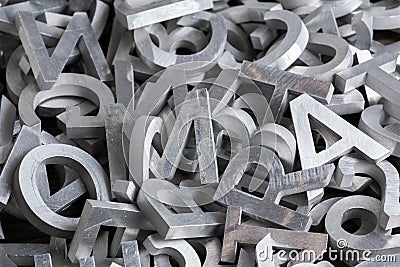 Pile of silver metal alphabet characters cutted by waterjet machine Stock Photo