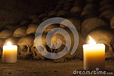 A pile of skulls laid on the ground at candle light in an ossuary Stock Photo