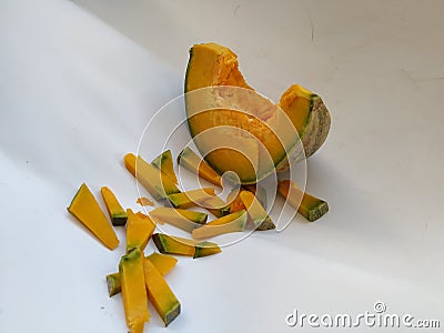 Pile of Sliced pumpkin on white background. Closeup Pumpkin Frame for text placement in a white backdrop Stock Photo