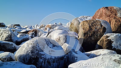 Pile of snowy rocks in the winter mountains on a sunny winter day with a blue sky Stock Photo