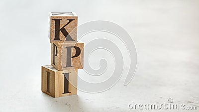 Pile with three wooden cubes - letters KPI meaning Key Performance Indicator on them, space for more text / images at right side Stock Photo