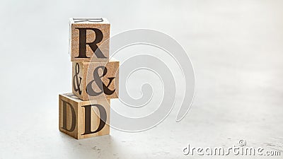 Pile with three wooden cubes - letters R&D meaning Research and Development on them, space for more text / images at right side Stock Photo