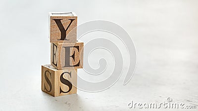 Pile with three wooden cubes - word YES on them, space for more text / images at right side Stock Photo