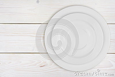 Pile of two white plates on bleached wooden plank background Stock Photo