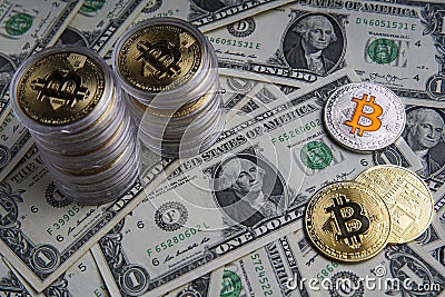 Pile of US dollar cash. Next to it are a number of gold bitcoins and a silver digital cryptocurrency coin. Stock Photo