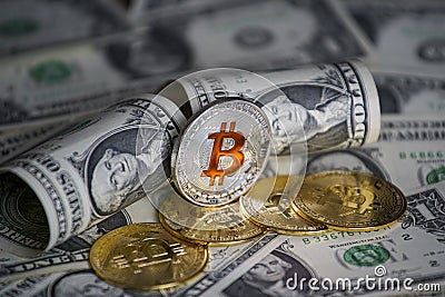 Pile of US dollar cash. Next to it are a number of gold bitcoins and a silver digital cryptocurrency coin. Stock Photo