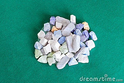 Pile of various multicolored stones on green table Stock Photo