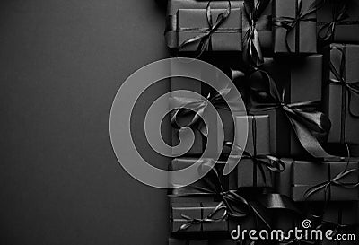 A pile various size black boxed gifts placed on stack. Christmas concept. Stock Photo