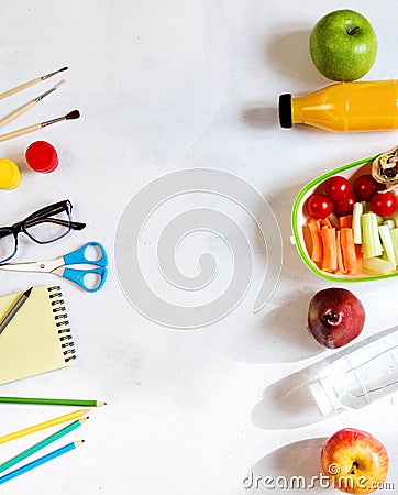 A pile of various stationery on table, notepad, colored pencils, ruler, marker, planer, space for text. Delicious school lunch box Stock Photo